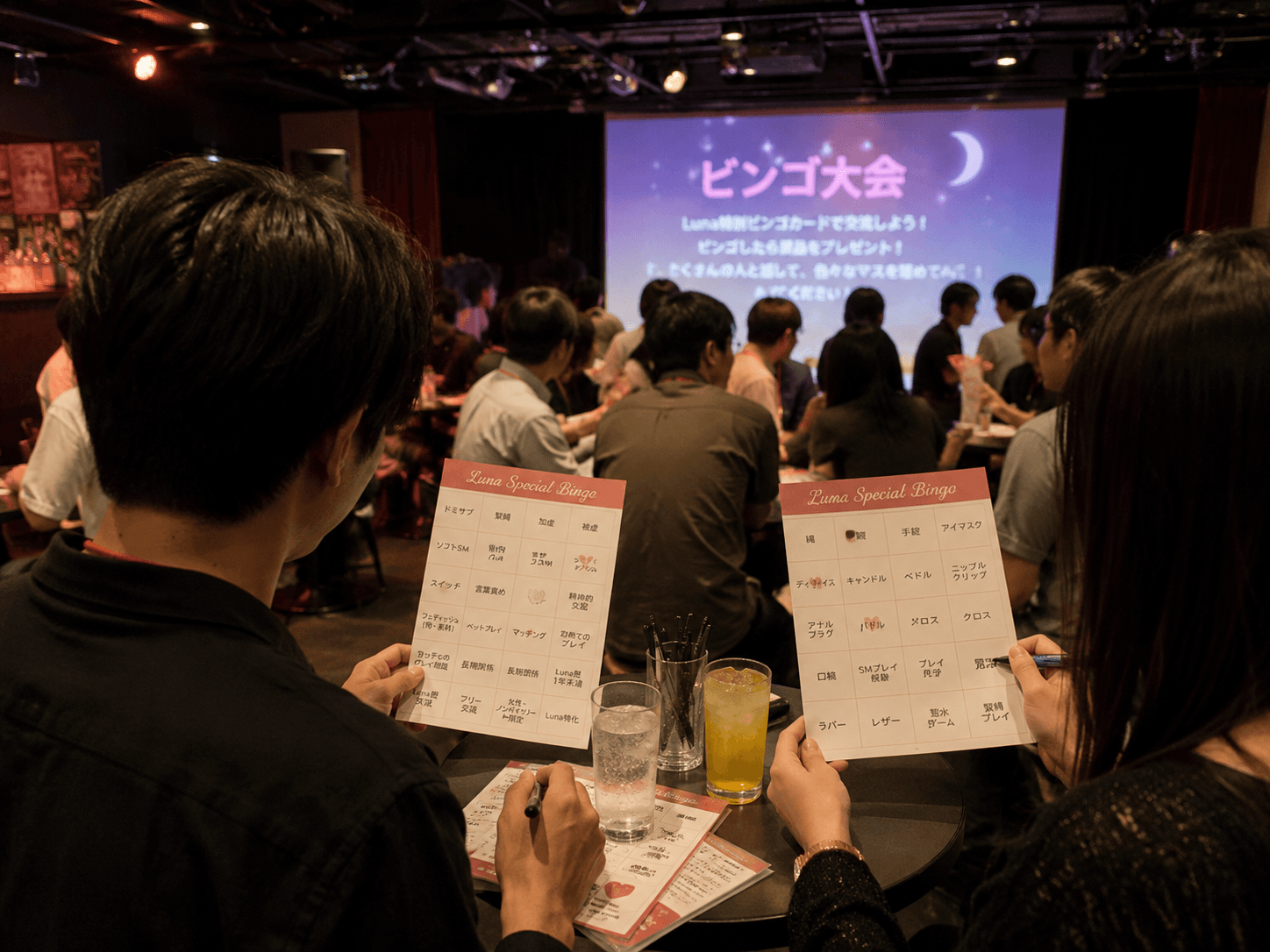 性癖ビンゴ大会のイメージ。Luna Special Bingo カードを手に交流する参加者